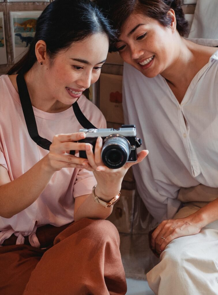 Photographer and woman entrepreneur reviewing digital images on a camera screen, collaborating to select the best shots that capture her professional essence. Preparing for Headshot Photography for Women