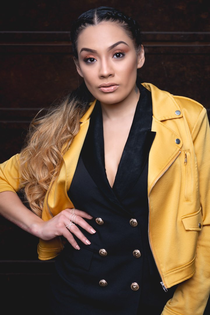 Artistic Emages Luxury branding photography in Dallas of a confident woman in a black double-breasted suit and bold yellow jacket, styled to project influence and authority.