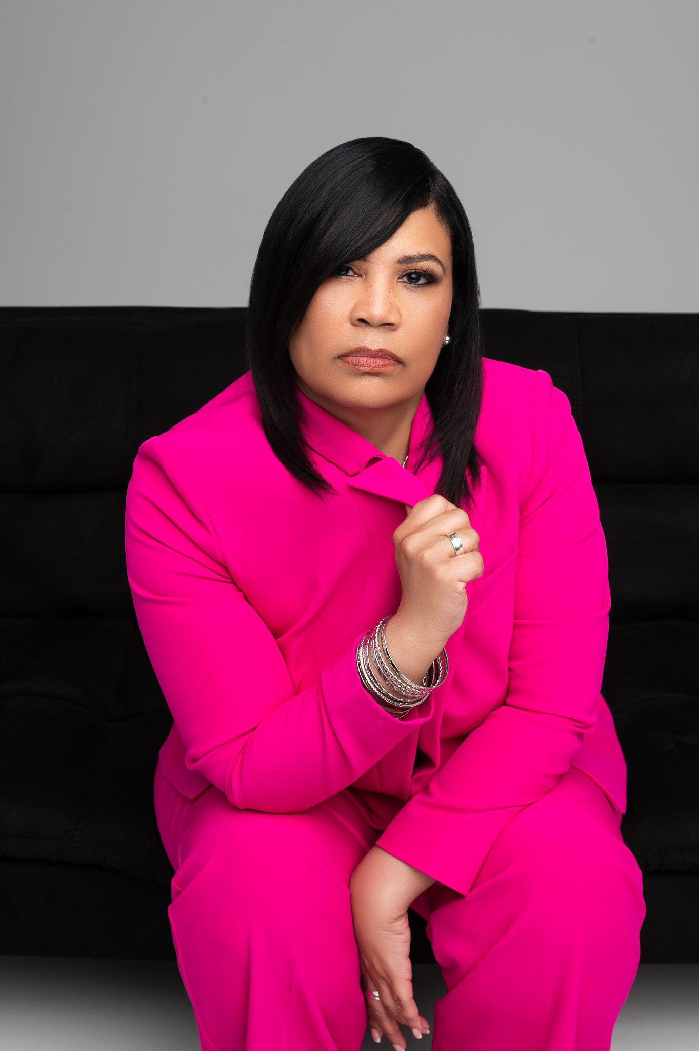 High end branding photographer Dallas portrait of a confident woman in a bold pink suit, styled for authority and executive presence.